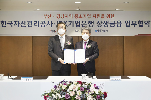 서울 중구 IBK기업은행 본점에서 열린 협약식에서 윤종원 IBK기업은행 은행장(오른쪽)과 문성유 한국자산관리공사 사장(왼쪽)이 기념촬영을 하고 있다(IBK기업은행 제공)