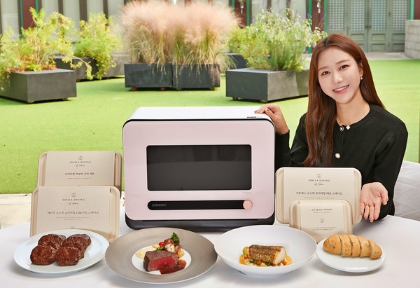 삼성전자 모델이 서울신라호텔 영빈관 앞에서 신개념 조리기기 '비스포크 큐커'와 전용 밀키트 '신라 다이닝 앳 홈' 3종을 소개하고 있다. 