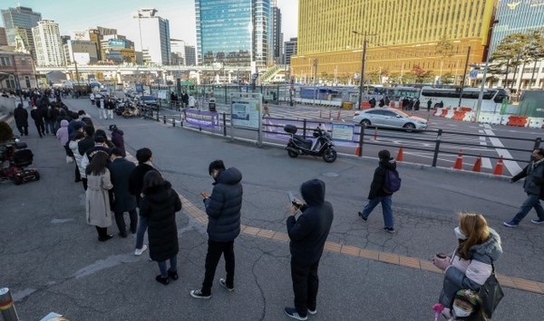 코로나19 신규확진자 수가 6,689명으로 집계된 12일 오후 서울 중구 서울역 광장에 마련된 신종 코로나바이러스 감염증(코로나19) 선별검사소 앞이 검사를 받으러 찾아온 시민들로 장사진을 이루고 있다.