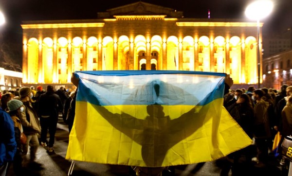 1일(현지시간) 조지아 수도 트빌리시의 의회 건물 앞에서 러시아의 우크라이나 침공에 반대하는 시위가 열려 한 참가자가 우크라이나 국기를 펼쳐 들고 있다.(뉴시스 제공)