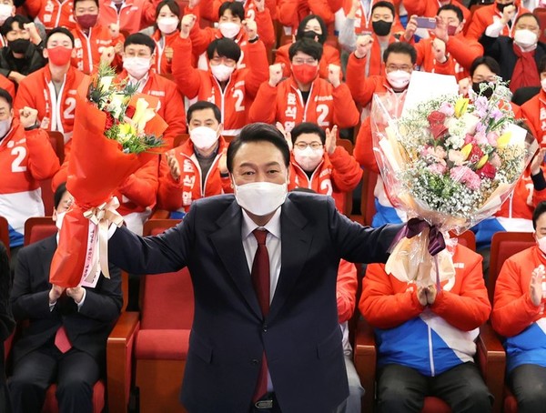 윤석열 제20대 대통령 당선인이 10일 새벽 서울 여의도 국회도서관에 마련된 국민의힘 제20대 대통령선거 개표상황실에서 꽃다발을 들고 있다.(뉴시스 제공)