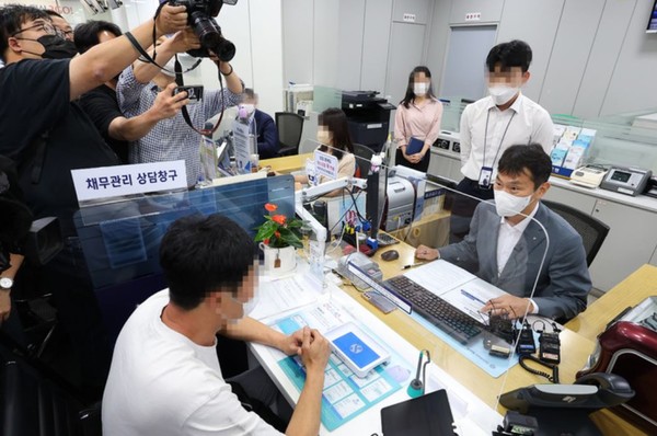 이복현 금융감독원장이 14일 오후 서울 중구 신한은행 남대문지점을 찾아 경제 여건 악화로 어려움을 겪고 있는 자영업자들의 금융 애로사항을 청취하는 간담회를 가진 후 고객과 대출 상담을 하고 있다. (공동취재사진)