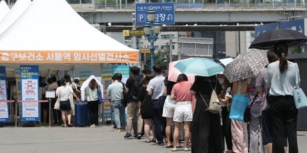 26일 서울 중구 서울역 신종 코로나바이러스(코로나19) 임시선별검소에서 시민들이 검사를 위해 길게 줄을 서고 있다