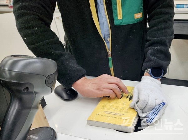 김진아 씨가 7000원에 구입한 공지영 작가의 책이다. 구입시 알라딘 직원이 중복구매 여부를 알려주지 않았으며, 이후 김진아 씨는 중복구매를 알게 됐다. 김진아 씨는 교환이 어렵다는 알라딘 직원의 말에 1500원에 해당 서적을 되팔았다. 이 책의 정가는 1만4000원이다. 알라딘이 정가의 10.7%수준으로 책을 사들여 50%로 판 것이다. 알라딘이 5500원의 폭리를 취한 것. 알라딘 직원이 가격 표를 서둘러 떼고 있다. [사진=팩트인뉴스]