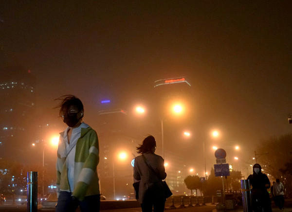 중국 베이징 주민들이 마스크를 쓰고 모래폭풍이 부는 거리를 걷고 있다. 이번 황사는 우리나라와 일본까지 영향을 미칠 전망이다. [사진=뉴시스]