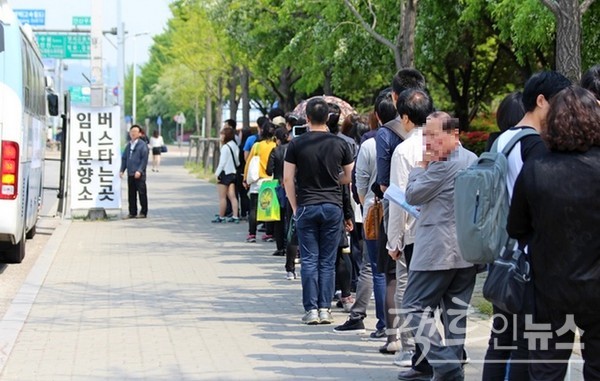 많은 국민이 세월호가 침몰한 다음날, 경기도 안산올림픽기념관에 설치된 분양소를 찾기 위해 수도권 전철 고잔역 앞 인도에 길게 줄서 있다. [사진=정수남 기자]