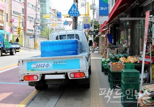 광동제약의 생수 배달차가 동네마트 앞 인도와 차도에 걸쳐 주차했다. [사진=정수남 기자]
