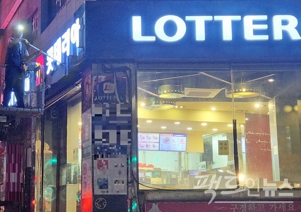 청소 전문 업체 직원이 패스트푸드점 간판을 닦고 있다. [사진=정수남 기자]