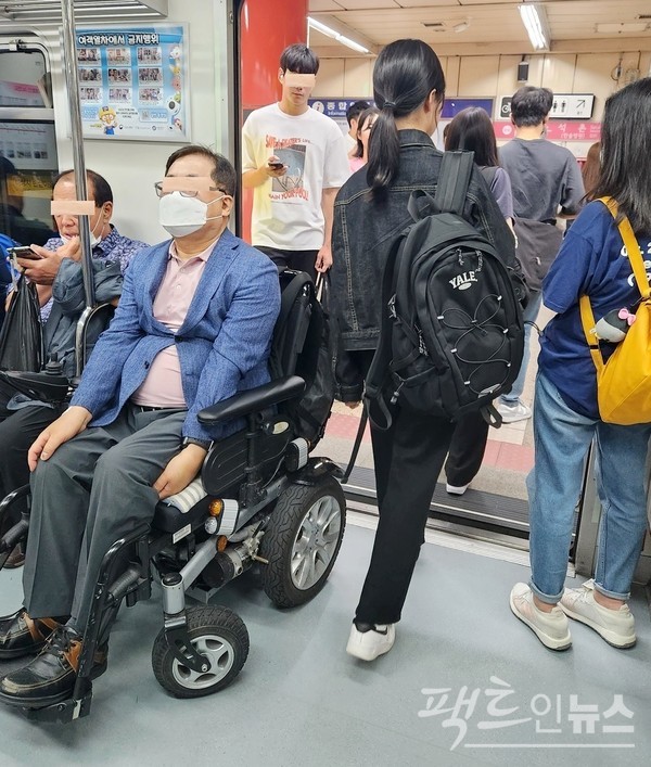 (위부터)20대로 보이는 여성이 만원인 지하철 객차 출입구 앞 바닥에 앉았다. 장애인 남성이 지하철 출입구를 막았다. 정상인이나 장애인이나 도긴개긴이다. [사진=정수남 기자]