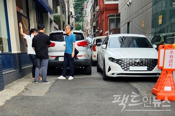 주택가 골목이다. 불법 주차 차량이 골목을 꽉 막은데 이어, 남성 흡연자 셋이 통행을 원천 차단하고 있다. [사진=정수남 기자]