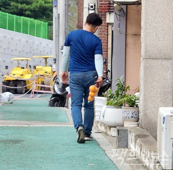 가장으로 보이는 50대 남성이 한 손에 오렌지 네 알이 든 봉투를 들고 걸어가고 있다. 자식에게 주기 위해서일까? 기운 오른쪽 어깨가 가장의 무게를 느끼게 한다. 지난주 퇴근길이다. [사진=정수남 기자]