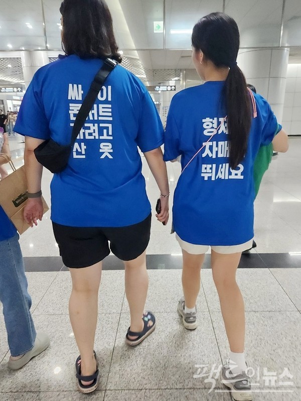 20대 초반 어성 네 명이 같은 옷을 입었다. 이들 가운데 두 명의 옷에는 가수 ‘싸이의 콘서트에 가려고 산 옷’이라는 글이 새겨져 있다. [사진=정수남 기자]