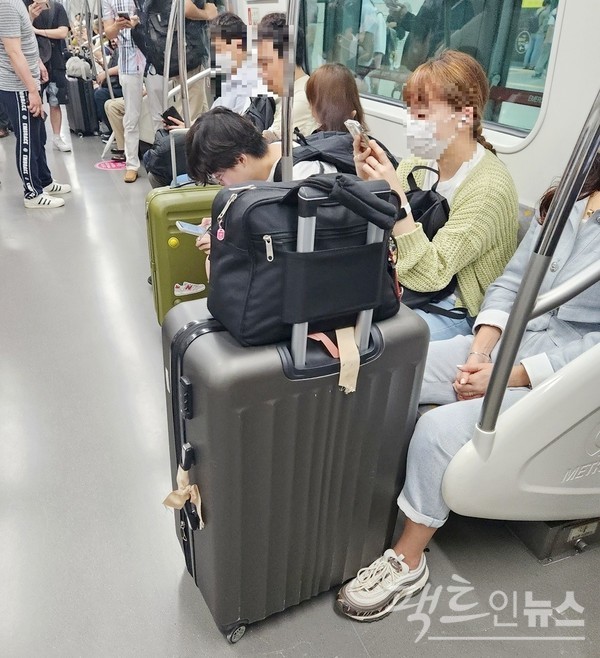 서울지하철 9호선 김포공항행 급행 첫차를 (위부터)당산역에서 20대 남성이 타고 있다. 열차 안에는 이미 20대 여행객들이 자리를 잡았다. [사진=정수남 기자]