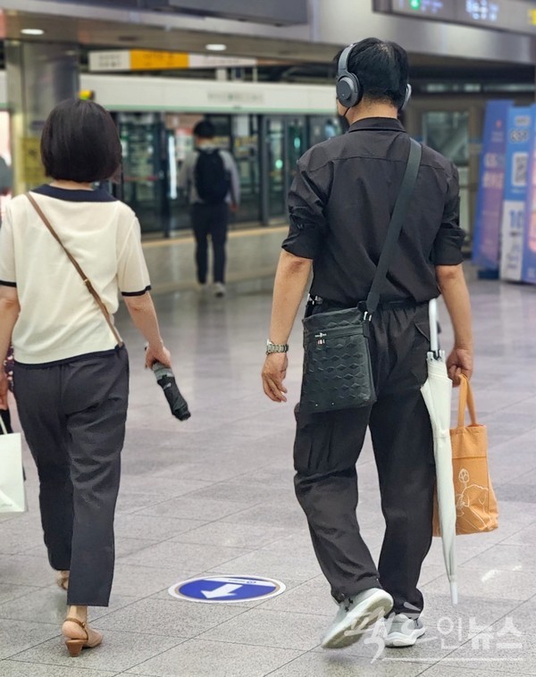 반면, 이 20대 청년처럼 우산 손잡이를 혁개 고리에 걸면 잃어버릴 염려가 없다. 기발한 특탄의 조치다. [사진= 정수남 기자]