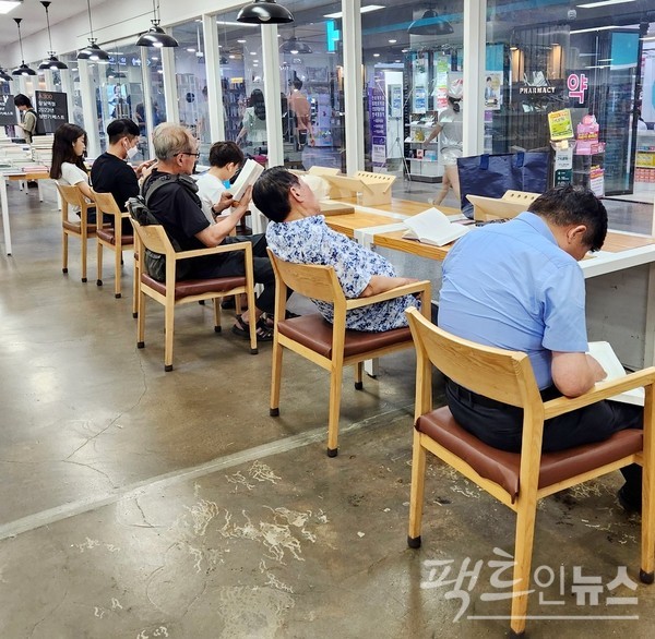 서점 안에 있는 독서대에서 고객이 책을 읽고 있다. 아래 사진에서 70대로 보이는 노인(오른쪽 두번째)이 책을 읽다 오수를 즐기고 있다. [사진=정수남 기자]
