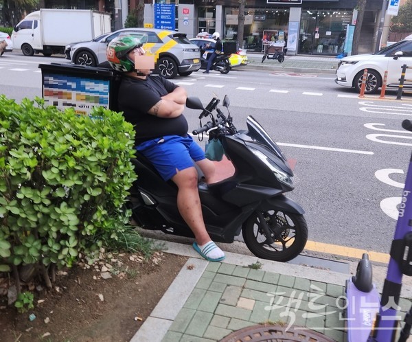 배달이륜차 운전자가 서울 마포 월드컵북로 갓길에서 주차 후 잠을 자고 있다. [사진=정수남 기자]