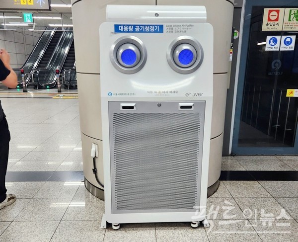 같은 날 오후 한 중년 여성이 대용량공기청정기 바람으로 무더위를 식히고 있다. 지나가는 30대 청년이 안타깝다는 시선을 보내고 있다. 서울지하철 9호선 당산역 승강장에서다. [사진=정수남 기자]