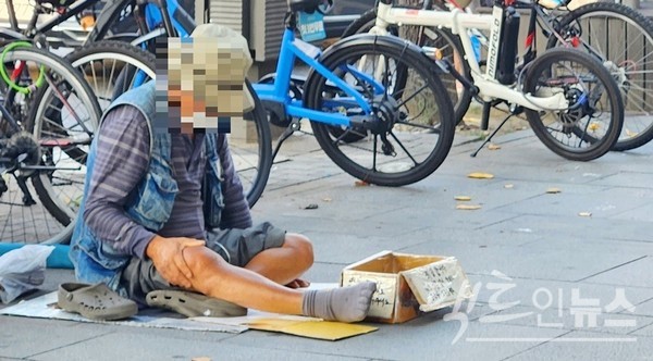 한 중년 남성이 ’몸이 아주 아파요, 조금만 도와주세요’라고 적은 종이 상자를 앞에 두고 구걸하고 있다. [사진=정수남 기자]