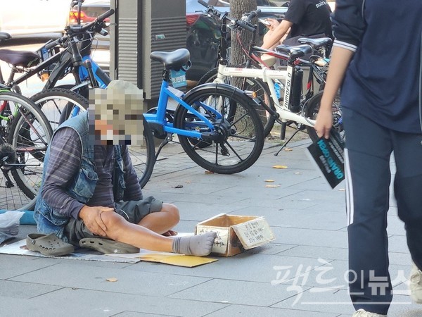 다만, 행인들은 스마트폰을 하면서 발걸음을 재촉하고 있다. 상자 안에는 돈이 없다. [사진=정수남 기자]