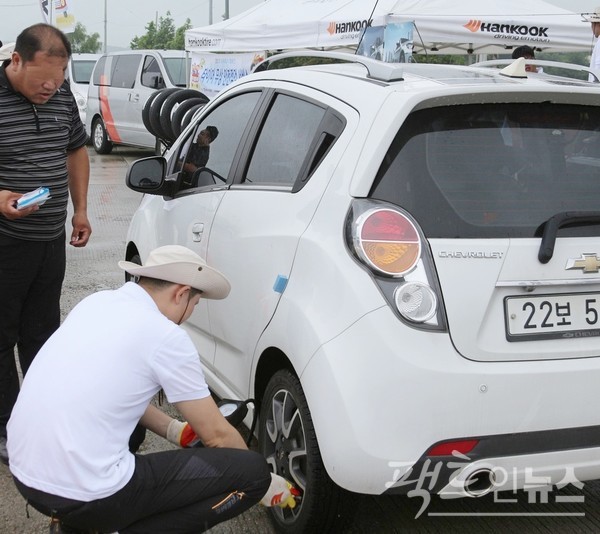 점검에서 전문가가 고객 차량의 타이어 공기압을 살피고 있다.  [사진=팩트인뉴스]