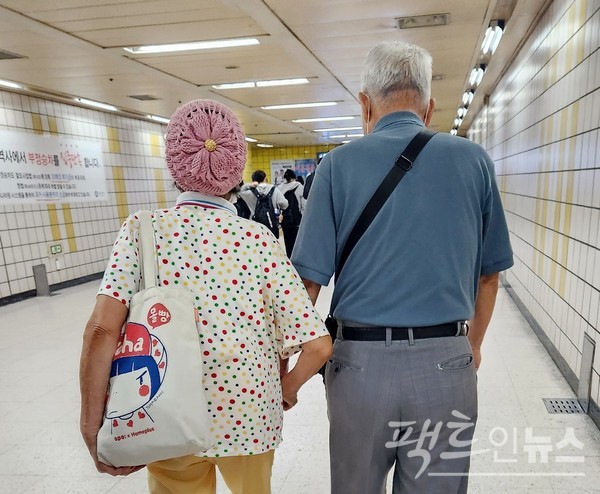 80대 부부가 손을 잡고 걸어가고 있다. [사진=정수남 기자]
