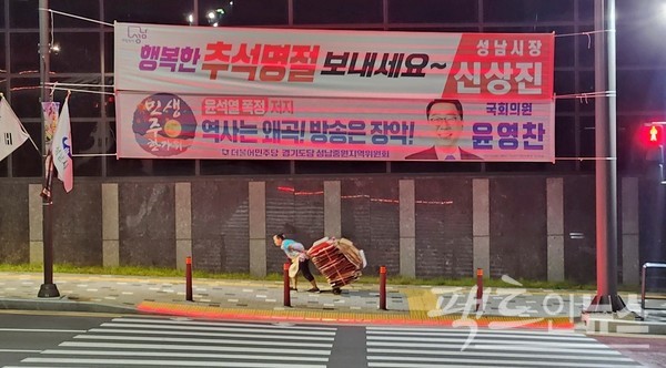 신상진 성남 시장과 윤영찬 의원이 중원구에 현수막을 각각 걸었다. 신상진 시장이 민생에, 윤영찬 의원이 정치 싸움에 각각 초점을 맞췄다. 윤영찬 의원도 일부 지역에 신상진 시장과 같은 현수막을 걸기도 했다. 70대 노파가 힘겹게 페지 손수레를 끌고 현수막 아래를 지나 가고 있다. 이 노파는 900미터 정도의 이 고개를 넘기 위해 항상 10번 이상의 다리쉼을 한다. 사진=정수남 기자]