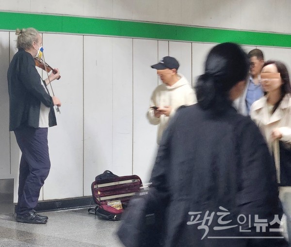 서울지하철 2호선 잠실역에서 8호선으로 갈아타기 위한 환승로에서 백인이 바이올린을 연주하면서 구걸하고 있다. 통상 선진국에서는 이처럼 무엇인가를 제공하고 구걸한다. [사진=정수남 기자]