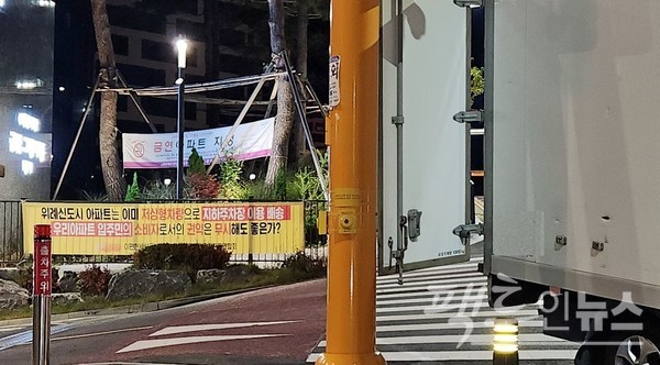 주민이 택배 차량 진입을 불허해 택배기사가 아파트 입구에 차량을 세우고 배달하고 있다. 아파트 주민이 현막을 통해 위례신도시처럼 저상 차량 배달을 주문하고 있다. [사진=정수남 기자]