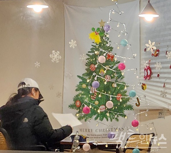 주택가에 자리한 24시간 영업을 하는 커피전문점도 성탄 트리를 만들었다. 공무원시험을 준비하는 공시생인지, 기말고사를 대비하는 대학생인지, 20대 여성이 공부로 밤을 밝히고 있다. [사진= 정수남 기자]