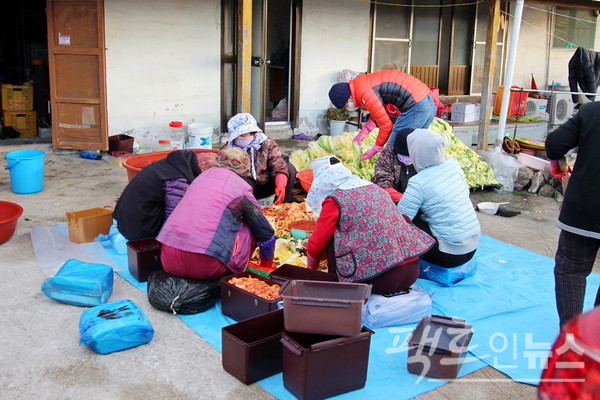 여자는 배추 속을 채우고, 남자는 김치냉장고에 들러갈 김치통을 채우고 있다. [사진=정수남 기자]