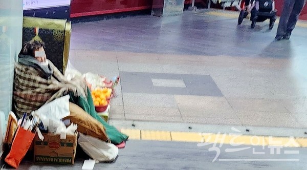 서울지하철 역사 입구에서 노점을 하는 노파가 이불 등으로 몸을 감쌌다. [사진=정수남 기자]