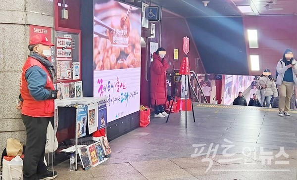 지하철 2호선 삼성역사다. 노인이 잡지를 팔고, 다른 노인이 구세군 모금 활동을 펼치고 있다. 행인은 스마트폰에 코를 빠뜨리고 무심히 지나간다. [사진= 정수남 기자]