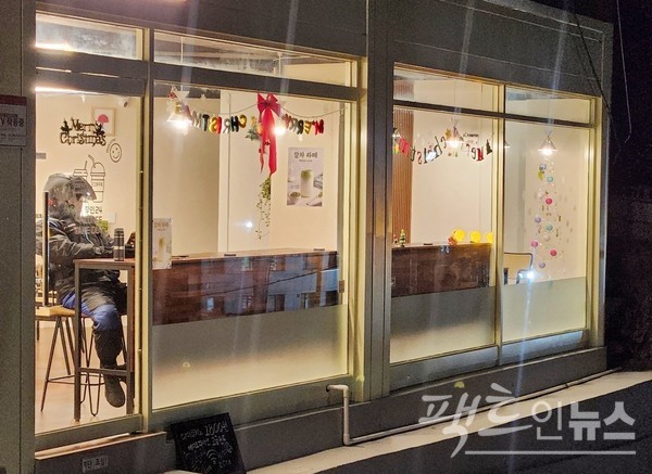 이달 중순 개점한 커피전문점에 배달 근로자가 새벽에 추위를 피하고 있다. 이 근로자는 “(커피전문점이)좋네요”라고 말했다. [사진=정수남 기자]