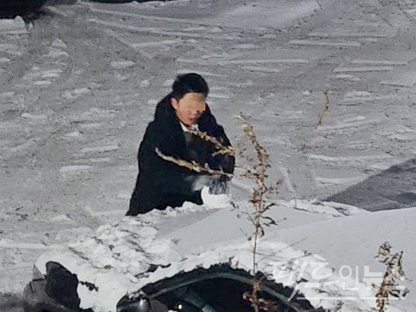 30대 남성이 주차한 차위에서 눈덩이를 만들고 있다. [사진=정수남 기자]