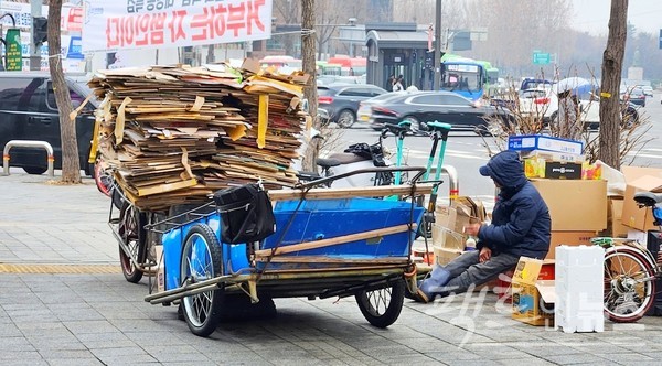 서울지하철 2호선 합정역 인근 인도에 60대 노인이 폐지를 줍다, 휴식하고 있다. 정오께다. [사진= 정수남 기자]