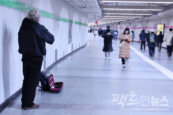 한 외국인이 바이올린을 켜면서 구걸하고 있지만, 대부분 행인이 이를 외면하고 지나간다. [사진= 정수남 기자]