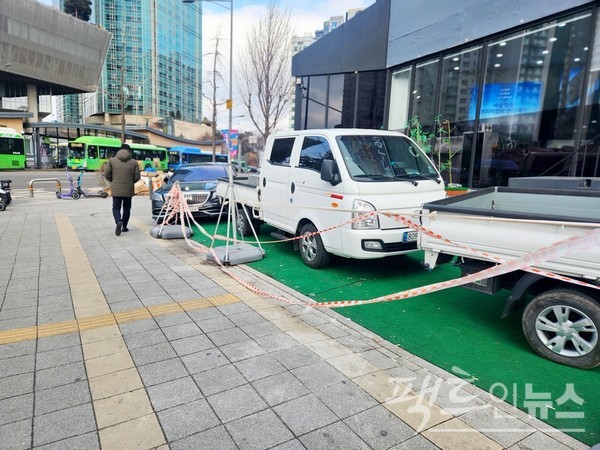 서울 양화대로 마포구 구간 인도다. 차량 가격이 2억원 중후반인 마이바흐 S560이 인도와 사유지에 걸쳐 주차했다. 불법 주차다. 초록색 부직포가 깔린 구간이 사유지다. 1톤 트럭은 불법주차가 아니다. [사진= 정수남 기자]