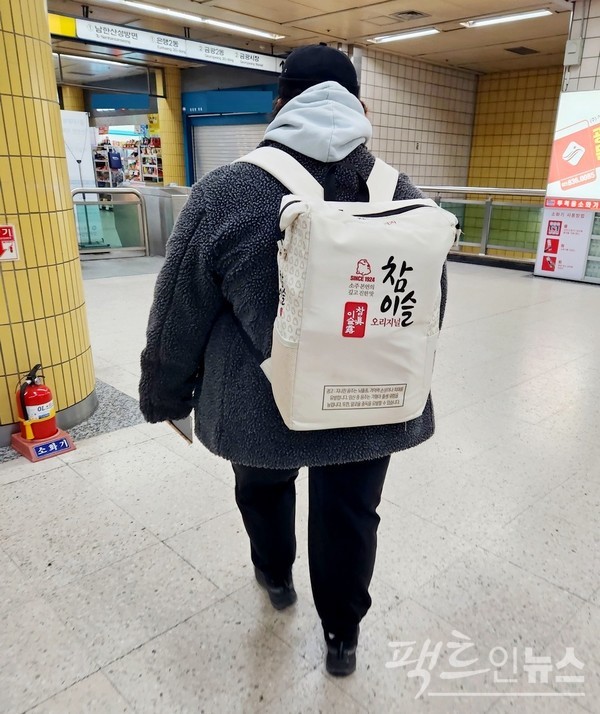 한 20대 여성이 하이트진로가 제공한 가방을 메고 있다. 보기 드문 가방이다. [사진=정수남 기자]