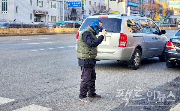 한 60대 노인이 지하철역 인근에서 2G폰으로 통화를 잘 하고 있다. [사진=정수남 기자]