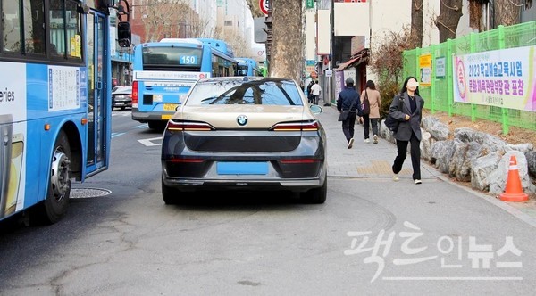 서울 종로구 대학로 효제초등학교 앞 인도와 버스 전용도로 사이에 BMW의 전기차가 불법으로 주차했다. [사진= 정수남 기자]