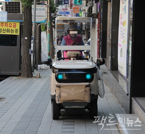 프레세 매니저가 인도 주행도 모자라, 인도에 정차해 스마트폰을 이용하고 있다. [사진=정수남 기자]