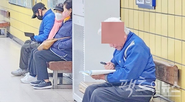 80대 노인이 스마트 전화기 대신 책을 들고 중국어 공부에 열심이다. [사진= 정수남 기자]
