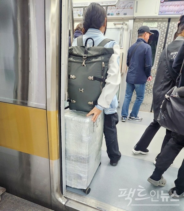 해외여행을 가는지 20대 여성이 내용물의 분실 등을 방지하기 위해 여행용 가방을 비닐로 꽁꽁 쌌다. [사진=정수남 기자]