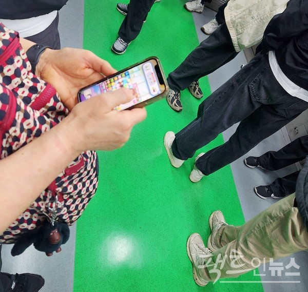  (위부터)계단 통행을 막는 무지막지한 스마트 전화기 이용자도 있고, 50대 아주머니는 40분째 게임이 열심이다. [사진= 정수남 기자]