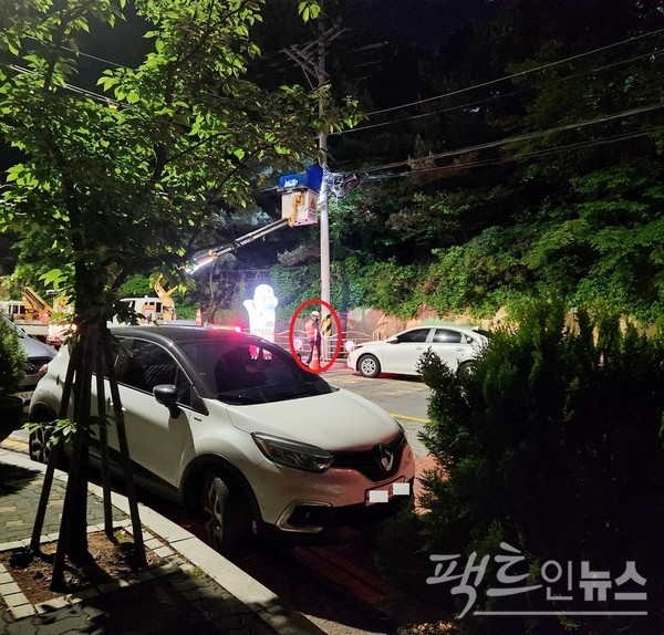 위 작업지에서 300m 떨어진 도로다. 편도 1차선 도로에서 새벽에 전기 관련 작업을 하고 있다. 차량 유도자(붉은 원) 2명이 차량 유도는 뒷전인 채 한곳에 모여 잡담을 하고 있다. 카메라를 들이대자, 한명의 유도자가 크레인 앞으로 갔다. [사진= 정수남 기자]