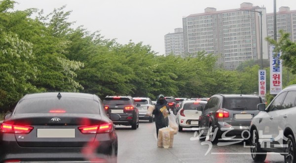 서해안고속국도 경기도 구간에 있는 인터체인지에서 50대 남성이 뻥튀기 과자를 최근 주말 팔고 있다. 비가 내려 자동차 배기가스가 가라 앉은 게 다행이지만, 같은 이유로 운전자와 탑승객이 뻥튀기 과자를 구매하기 위해 창을 내리지 않는다. [사진= 정수남 기자]