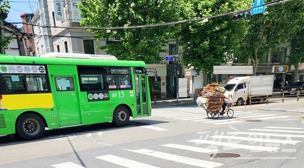 (위부터)60대 남성이 전전거를 개조한 삼륜차에 폐지를 가득 싣고 편도 2차선 도로에서 차선 줄타기를 힘겹게 하고 있다. 버스가 자전거 속도에 맞춰 100미터 정도를 뒤따르다 경적을 울리자, 자전거가 2차로로 피하고 있다. 이륜차의 경우 도로 우측 편으로 주행해야 한다. [사진=-정수남 기자]