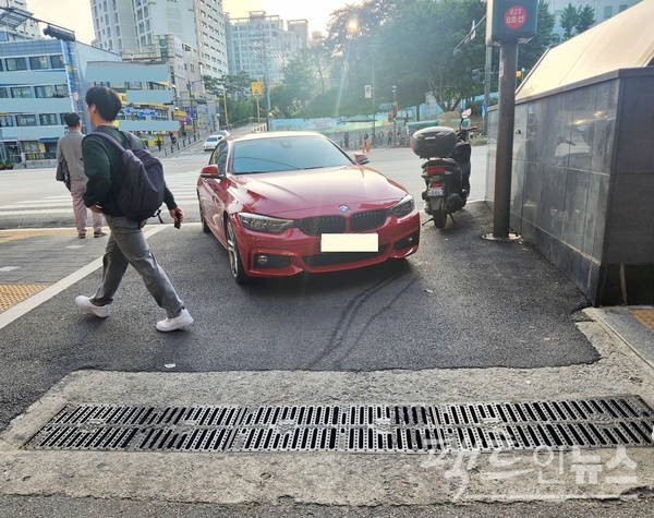 서울지하철 8호선이 지나는 경기도 도시다. 대로에서 주택가로 들어가는 입구에 BMW의 중형 세단이 주차했다. 차량 통행이 원천 불가능하다. 게다가 이곳이 지하철 출입구 사이면서, 횡단보도 시점이다. [사진=정수남 기자]