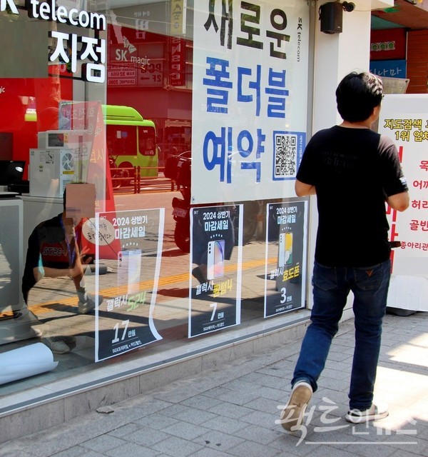한 이동통신 대리점이 스마트 전화기 마감 판매를 알리는 포스터를 부착하고 있다. 다만. 이번 마감 판매가 새로운 제품에 따른 것이다. 마감이 마지막과 달라, 마감에 끝이 없는 셈이다. [사진=정수남 기자]