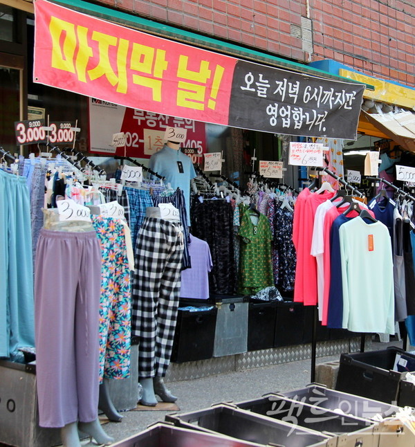 바로 옆 폐업한 부동산사무실에서 영세 자영업자가 염가로 옷을 팔고 있다. 이날이 마지막 영업일이다. 끝이다. 고객의 아쉬움을 자극하는 마케팅 기법이다. [사진= 정수남 기자]